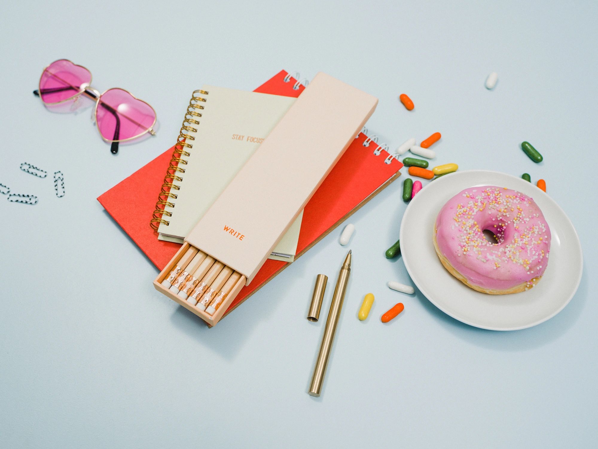 Flat lay of stationery items including notebook and pencils
